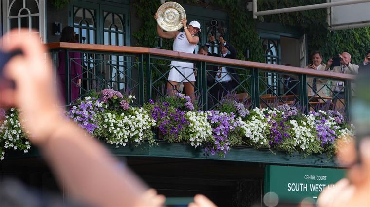 „Königin von Wimbledon“ Swiatek rechnet mit Kritikern ab Iga Swiatek präsentiert den Fans vom Balkon die Trophäe.