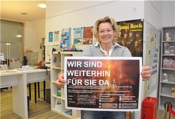 Ilona Tetzlaff, Geschäftsführerin von Nordenham Marketing & Touristik, mit einem Plakat, das die Kunden über die Angebote des Einzelhandels während des Lockdowns informiert.