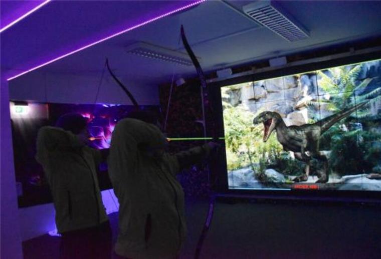 Im Bogenschießkino in Bremerhaven ist Spaß vorprogrammiert Bogenschützen vor Dino