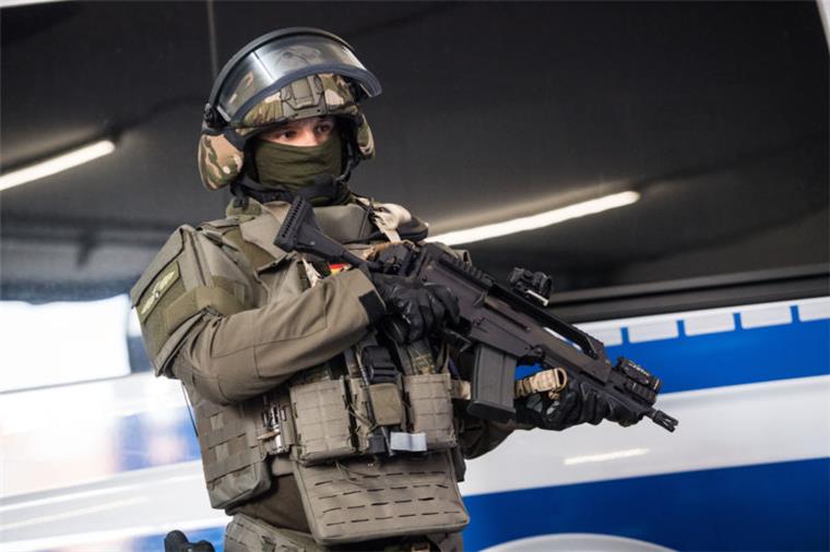Terrorübung am Bremer Hauptbahnhof mit Schüssen und Explosionen Ein SEK-Beamter steht mit seiner neuen Ausrüstung vor einem Polizeifahrzeug.