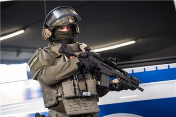 Ein SEK-Beamter steht mit seiner neuen Ausrüstung vor einem Polizeifahrzeug.
