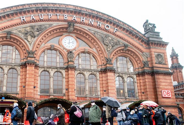 Zahlreiche bedürftige Menschen stehen an Heiligabend in einer Schlange vor dem Kältebus der Johanniter auf dem Vorplatz am Bremer Hauptbahnhof.