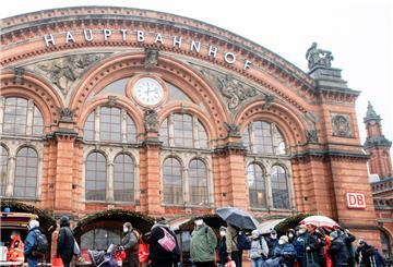 Zahlreiche bedürftige Menschen stehen an Heiligabend in einer Schlange vor dem Kältebus der Johanniter auf dem Vorplatz am Bremer Hauptbahnhof.