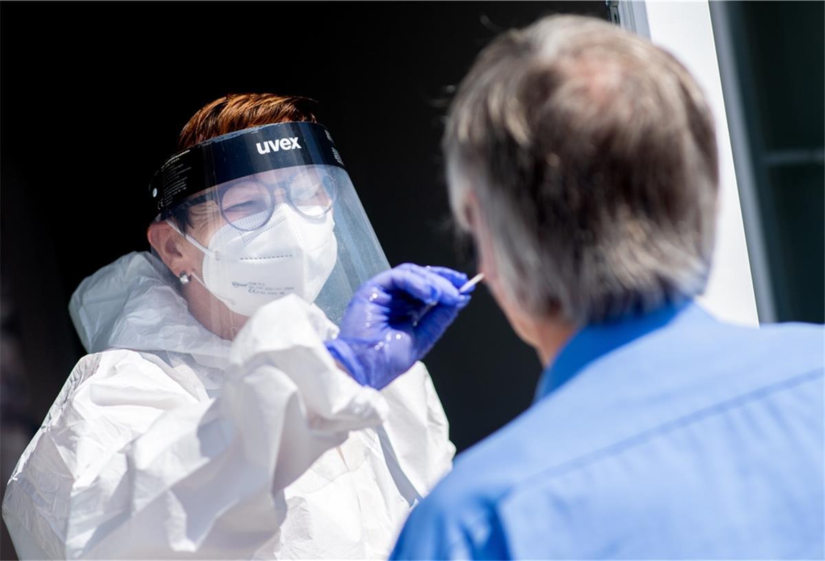 Corona im Cuxland: 20 Neuinfektionen Eine Mitarbeiterin eines Testcenters am Fähranleger nimmt einen Abstrich von einem Touristen