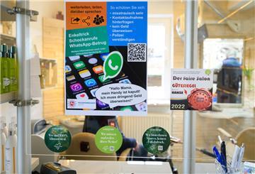 Im Friseursalon hängt ein Plakat, das auf den sogenannten Enkeltrick und Schockanrufe hinweist. 
