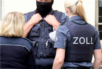 Beamte des Zoll betreten bei einer Razzia ein Gebäude
