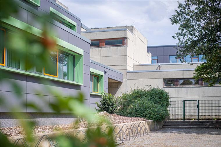 Im Hintergrund die noch unsanierte Fassade des Schulzentrums Sophie Scholl in Bremerhaven und links daneben die bereits energetisch umgestaltete Außenwand. 