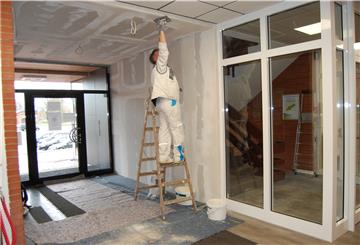 Im Inneren sind die Arbeiten in vollem Gange. Der Haupteingang erhielt eine neue Tür, die ohnehin defekte Schiebetür des Windfangs entfernt. Das Treppenhaus (rechts) ist jetzt durch Glas- und Türlemente abgeschottet.