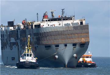 Schlepper ziehen den schwer beschädigten Autofrachter "Fremantle Highway" in den Hafen. Heute hat die "Fremantle Highway" einen neuen Namen. Sie heißt nun "Floor".