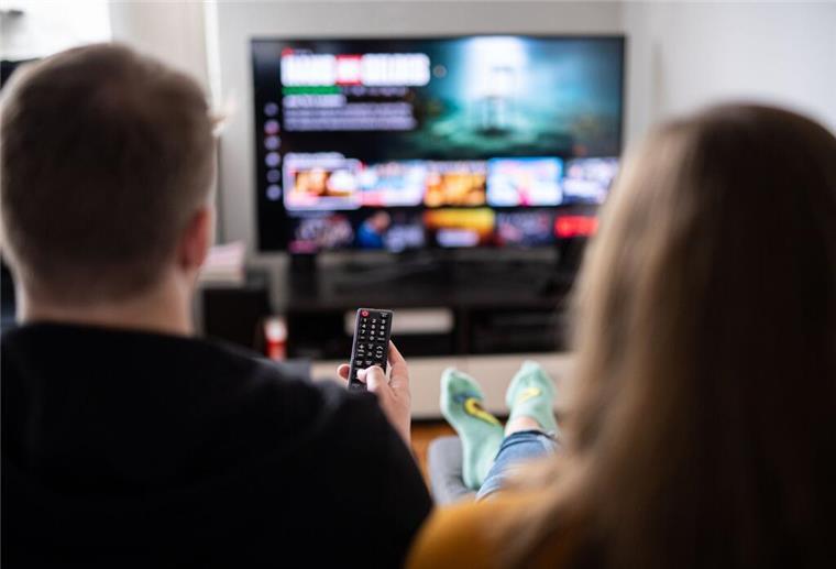 TV-Änderung im Juli: Kultiger Doku-Sender wird gestrichen Ein Paar sitzt vor dem Fernseher, der Mann hält die Fernbedienung.