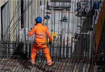 Ein Bauarbeiter verlegt auf einer Baustelle Stahlmatten.