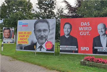 Wahlplakate zur Bundestagswahl 2021 stehen auf einer Wiese. 