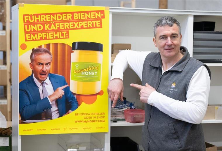 Imker Rico Heinzig neben einem Plakat mit dem Foto des Moderators Jan Böhmermann.