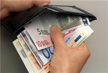 Ein Mann verstaut einige Euro-Geldscheine in seiner Geldbörse.