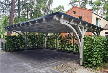 Ein weißer Carport mit einem dunklen Dach.