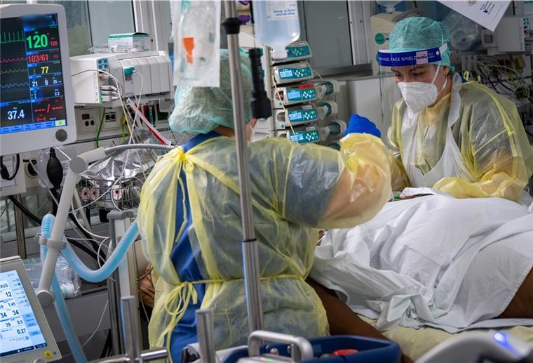 Ein Patient wird auf der Covid-19-Intensivstation des Klinikum „Rechts der Isar“ von Fachkräften medizinisch betreut.