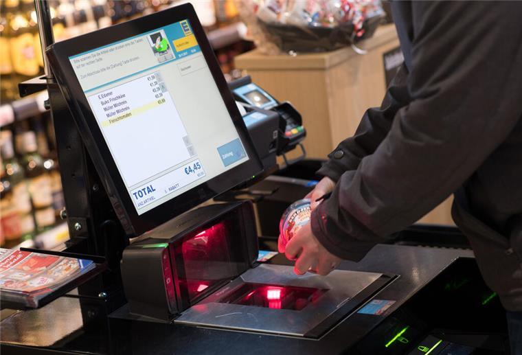 Versteckte Überwachung: Wie SB-Kassen Kundenbewegungen analysieren Eine Frau scannt in einer Rewe-Fliale ein Produkt an einer Selbstbedienungskasse.