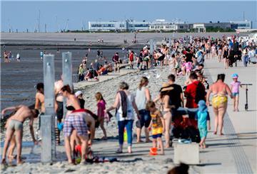 Zahlreiche Strandkörbe und Strandzelte stehen bei sonnigem Wetter am Strand