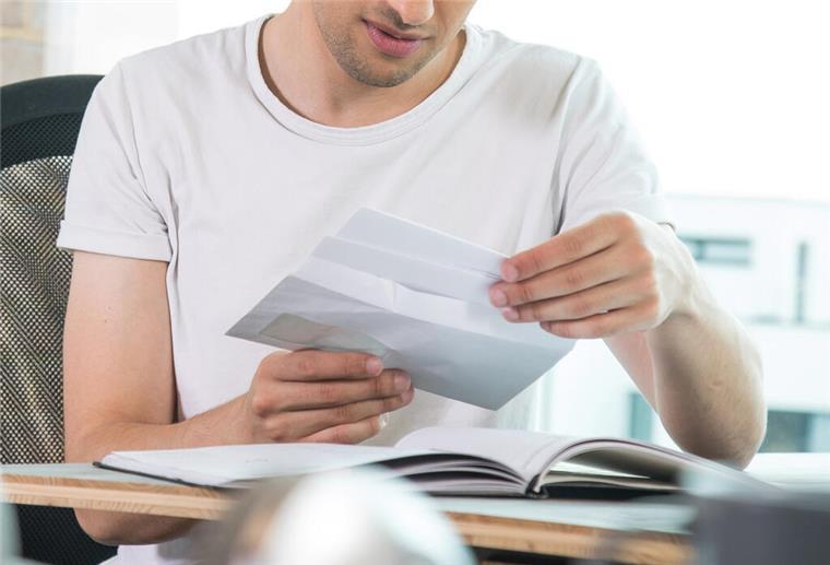 Wirtschafts-Identifikationsnummer kommt: Diese Steuerzahler sind betroffen Ein Mann schaut sich einen Brief an.