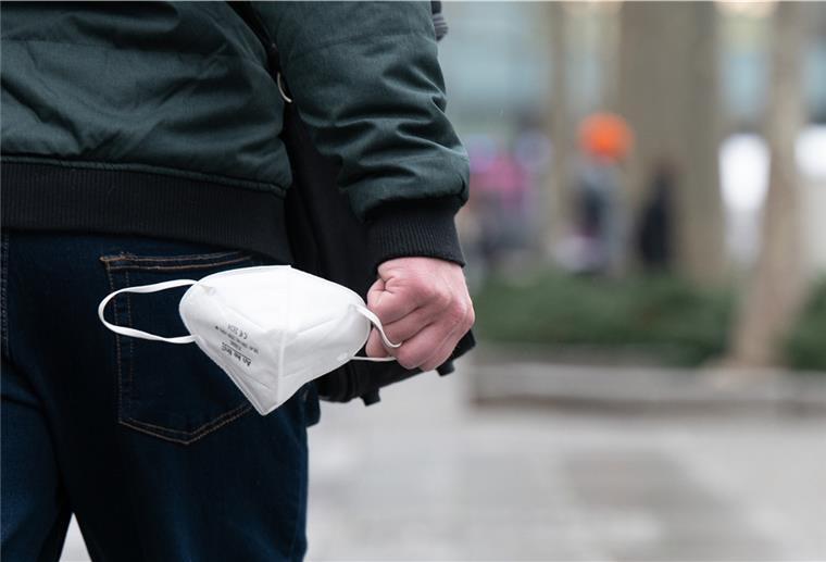 Niedersachsen erwägt Corona-Übergangsregeln bis Anfang April Ein Mann trägt auf der Einkaufsstraße Prager Straße eine FFP-2-Maske in der Hand.