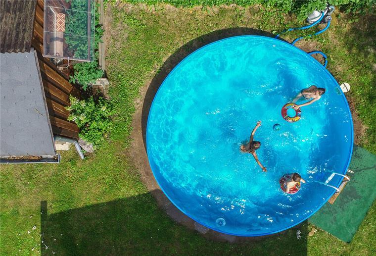 Ferienhaus mit Pool: So krass ist der Aufpreis durch den Luxus Mehrere Personen schwimmen in einem Pool.