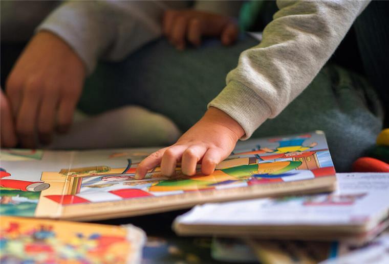 „Schwarze Kinderbibliothek“ in Bremen eröffnet neue Räumlichkeit Eine Kinderhand zeigt auf ein Buch.