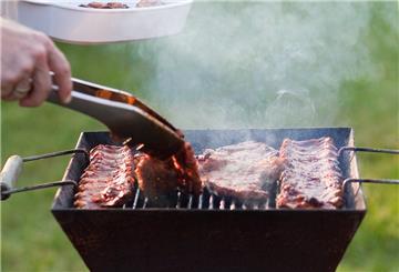  Ein Mann grillt in seinem Garten
