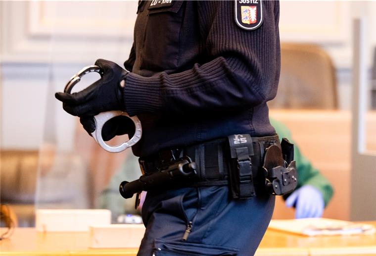 Sexuelle Nötigung: Polizist wird festgenommen Ein Justizbeamter verlässt mit Handschellen den Platz des Angeklagten ab.