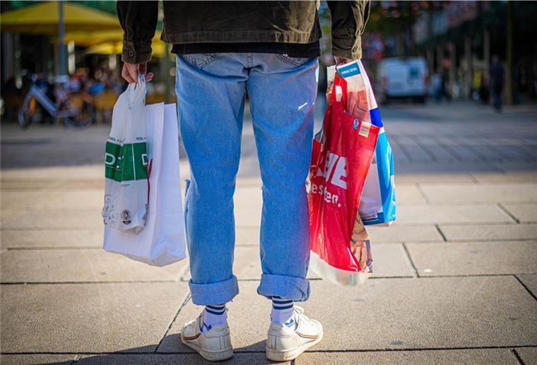 Mann mit Plastiktüten in der Fußgängerzone