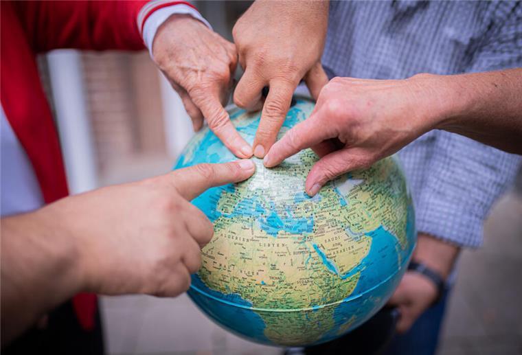 Symbolfoto Globus mit Fingerzeig auf Deutschland/Bremerhaven zum Thema Migration.