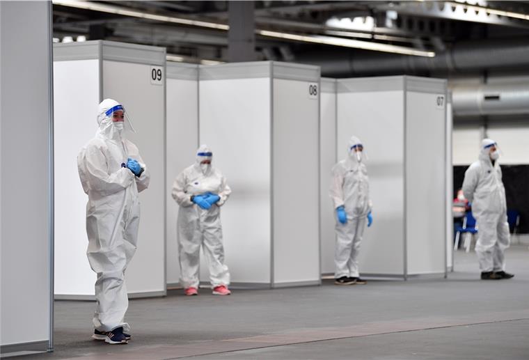 Zwei weitere Teststationen in Bremerhaven Mitarbeiter in Schutzkleidung stehen im Corona-Testzentrum in der Messe Erfurt bereit.