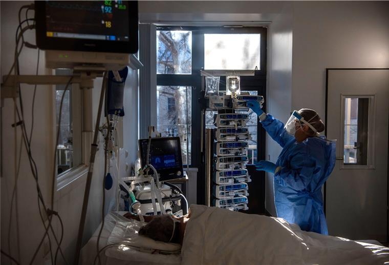 Corona in Bremerhaven: 14 Neuinfektionen am Sonntag Eine Krankenschwester in Schutzkleidung kümmert sich um einen beatmeten Patienten auf der Intensivstation