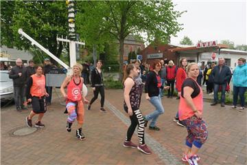In Burhave tanzte eine Gruppe Mädchen und Frauen unter dem Maibaum Zumba.