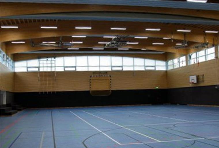 Sittensen: Beim Duschen in der Sporthalle wird es jetzt kalt Durch Fenster kommt Licht in eine leere Turnhalle mit blauem Boden der Samtgemeinde Sittensen.