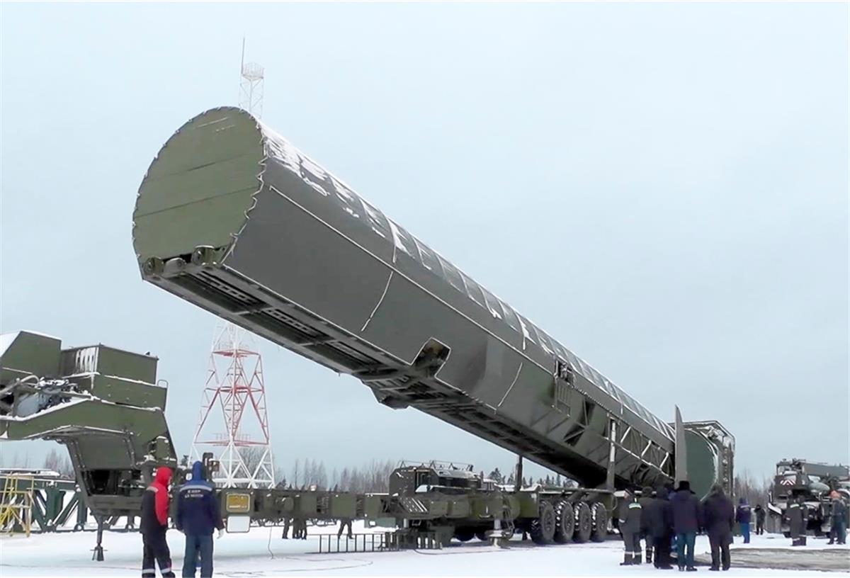 Eine riesige Abschussvorrichtung für eine Rakete ist umringt von einigen Soldaten.