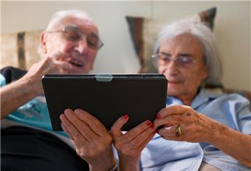 Helmut Wittmann und seine Ehefrau Ursula (beide 87) sitzen mit einem Tablet-Computer auf dem Sofa ihres Zimmers.