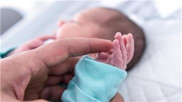 Ein Vater hält die Hand eines wenige Tage alten Jungen. Die Helios-Klinik Cuxhaven schließt vorübergend  die Geburtshilfe und den Bereich Kinder- und Jugendmedizin.