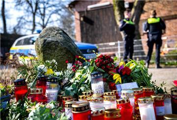 Blumen und Kerzen vor einem Einfamilienhaus.