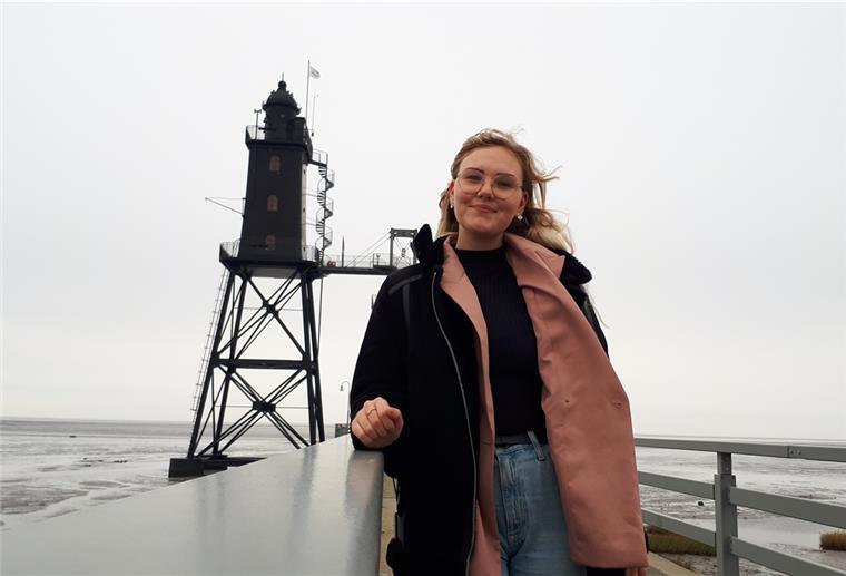 Dieser Top-Azubi arbeitet in Dorum-Neufeld Eine Frau steht auf der Brücke. Im Hintergrund ist ein Leuchtturm.