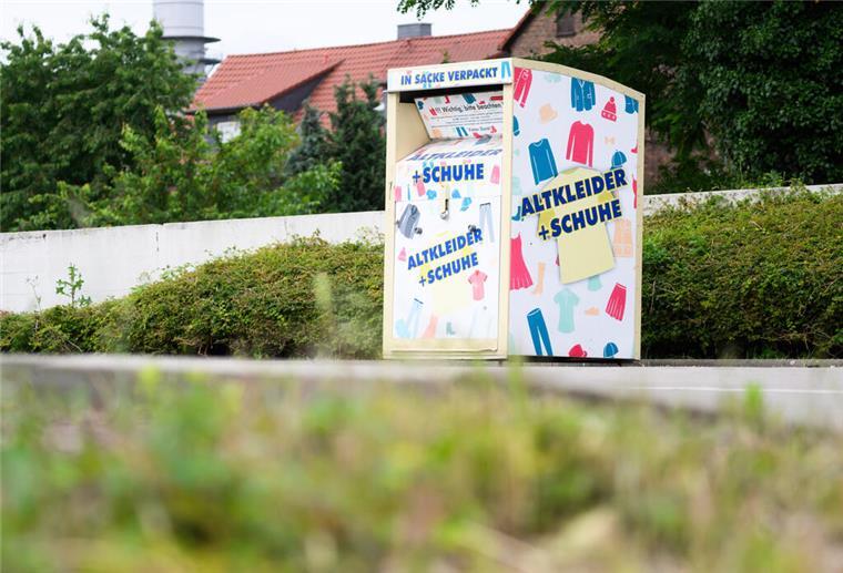 Ein Altkleidercontainer steht auf einem Supermarkt-Parkplatz.