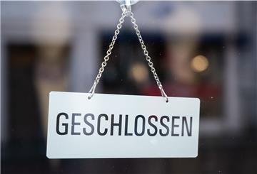In einem Schaufenster in einer Fußgängerzone hängt ein Schild mit der Aufschrift „geschlossen“.