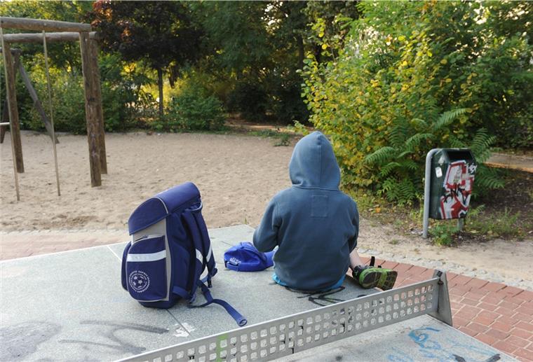 Bremerhaven: Familienschule ist eine neue Chance für schwierige Kinder Ein Kind sitzt mit dem Rücken in die Kamera auf einer Tischtennisplatte.