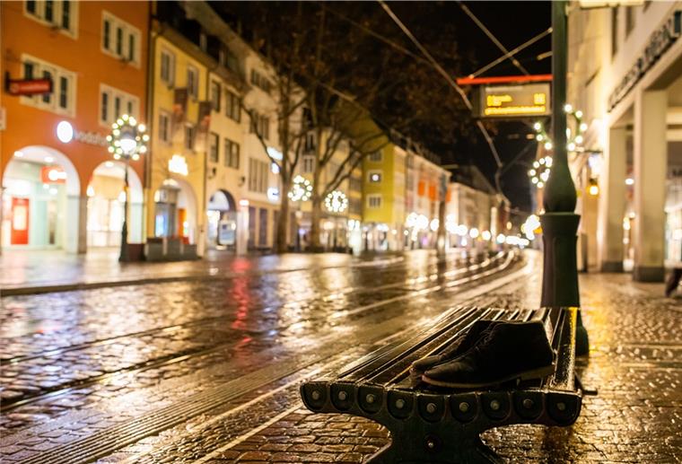Baden-Württemberg, Freiburg: Ein herrenloses Paar Schuhe steht in der Innenstadt auf einer Bank.