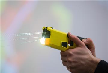 Ein Polizeibeamter demonstriert einen Schuss mit einem Distanzelektroimpulsgerät (DEIG oder auch Taser).