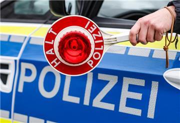  Ein Polizist hält eine Polizeikelle für eine Kontrolle 