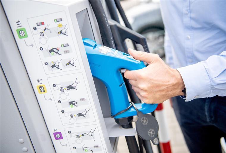 Parkplatz-Sperrungen in Hagen: Bau von E-Ladesäulen beginnt ein Mann greift an einer Ladesäule zum Ladekabel