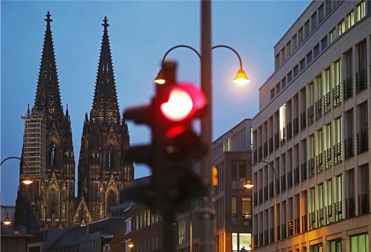 Corona-Infektionen: Köln und Essen knapp unter wichtiger Grenze Kölner Dom und rote Ampel, Nachtaufnahme.