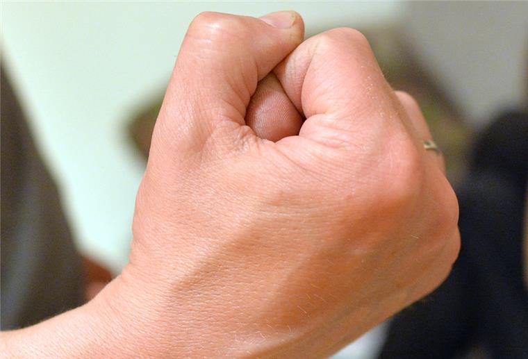 Eine Frau versucht, sich vor der Gewalt eines Mannes zu schützen.