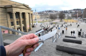  Eine Hand hält ein Messer in der Hand (gestellte Szene), im Hintergrund der Schlossplatz.  In mehreren Großstadtbahnhöfen gilt ab Mai 2025 ein verlängertes Verbot für Waffen und Messer.