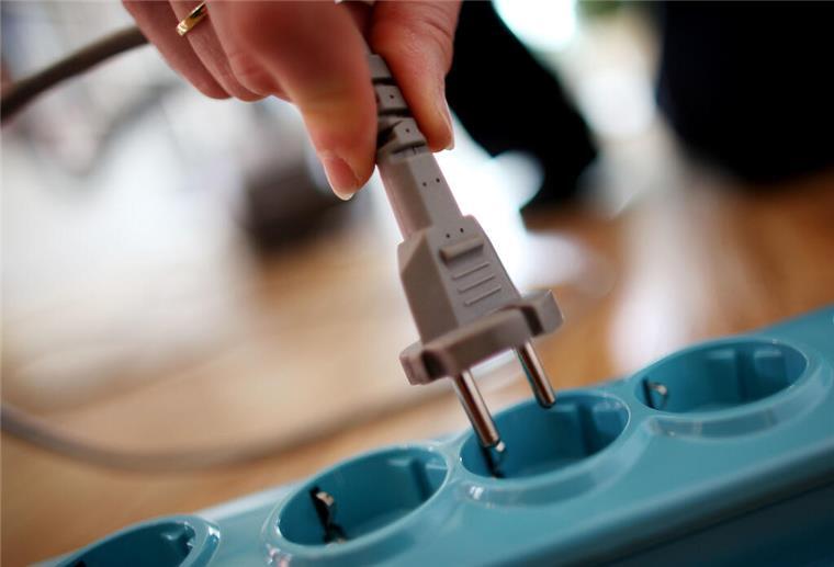 Neue Regel für Stromkunden betrifft Millionen Haushalte: Was sich ab Juni ändert Eine Person zieht einen Stecker aus einer Steckdose.